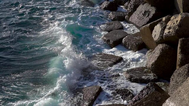 Stormy beautiful waves are crushing on huge rocks on the sea coast in Cadiz.