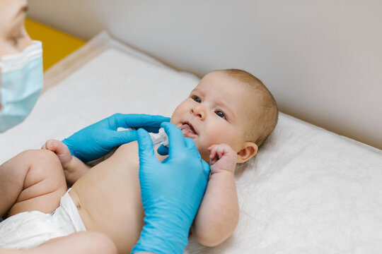 Pediatrician administring oral vaccination against rotavirus infection to little baby. Children health care and disease prevention. 