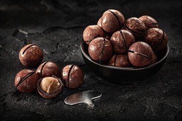 Nuts Of Macadamia In Black Bowl On Dark Background
