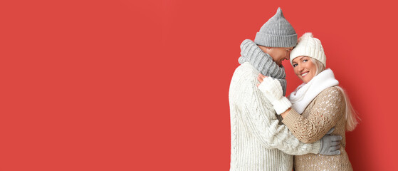 Portrait of happy mature couple on red background with space for text