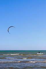 Kitesurfer flying over the waves in Ebro river delta national park, one of the most amazing spots in the Spanish seaside (all brand names and logos removed from the kite and the board).