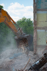 Demolition of building. Excavator breaks old house. Freeing up space for construction of new building