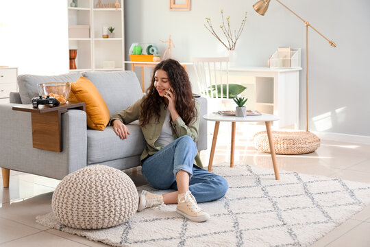Teenage girl talking by mobile phone at home