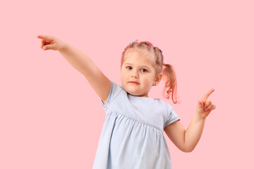 Funny little girl showing loser gesture on pink background