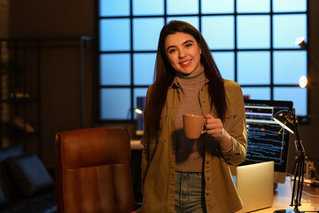 Young female programmer drinking coffee in office