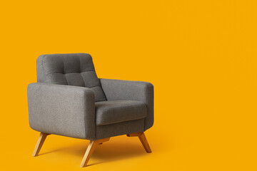 Cozy grey armchair on orange background