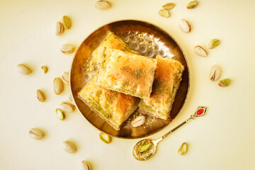 Plate with tasty baklava on yellow background