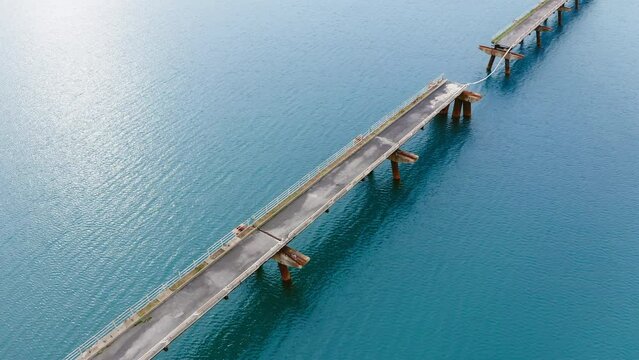 Abandoned and damaged industrial pier on the sea
