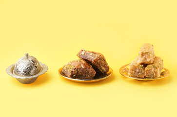 Plates with tasty baklava on yellow background