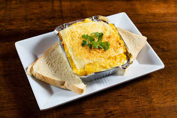 Hot lasagna, served in an aluminum container - Colombian preparation