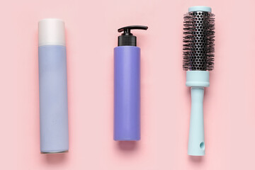 Round brush with hair sprays on pink background