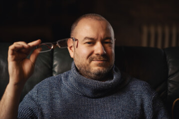 Middle-aged man with glasses in his hands. Vision problems, reading glasses.