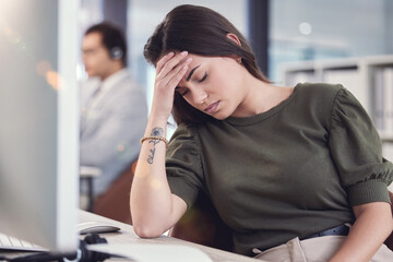 This headache came at the worst time. a young female call center agent suffering from a headache at...