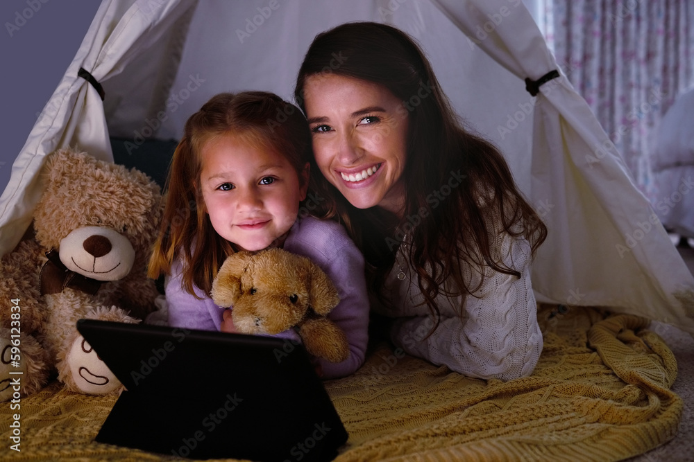 Poster We indulge in some extra screen time on the weekend. a little girl and her mother watching something on a digital tablet at night.