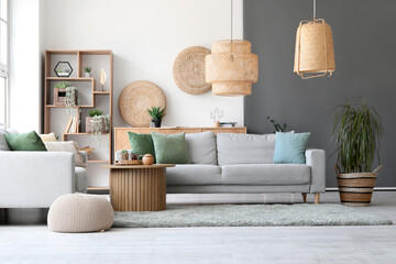 Interior of stylish room with cozy grey sofas and coffee table on soft rug