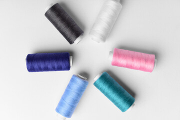 Composition with different thread spools on light background