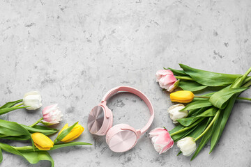Composition with modern headphones and beautiful tulip flowers on grunge background