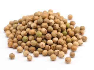 A pile of brown seeds with a green leaf on top.