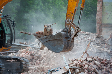 Demolition of building. Excavator breaks old house. Freeing up space for construction of new building