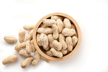 Peanuts in a wooden bowl on white background.
