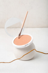 Decorative plaster podium with powder, brush and tree branch on white table