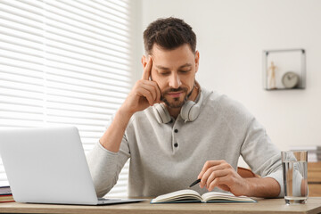 Man studying on laptop at home. Online translation course