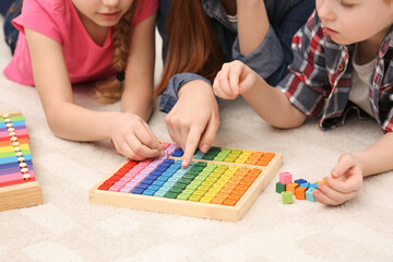 Mother and children playing with different colorful cubes and equations on floor, closeup. Learning...