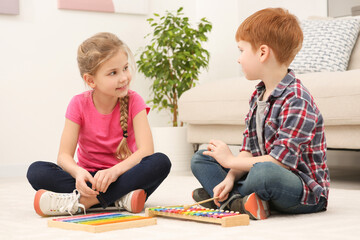 Children playing with different math game kits on floor in living room. Study mathematics with...