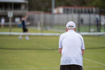 Amateur playing tennis at a tournament and match on grass in Europe 