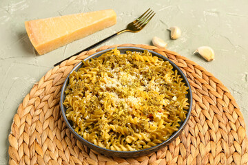 Plate of tasty Italian pasta with Parmesan cheese on light background
