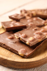 Sweet tasty chocolate with nuts on  table, closeup