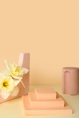 Decorative plaster podiums with flowers on beige background