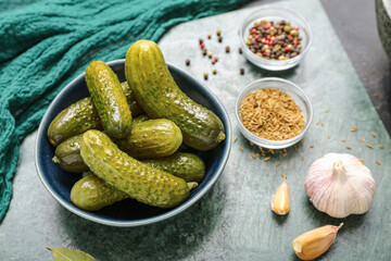 Bowl with tasty fermented cucumbers on dark grunge background