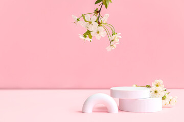 Decorative podiums and blooming branches on pink background