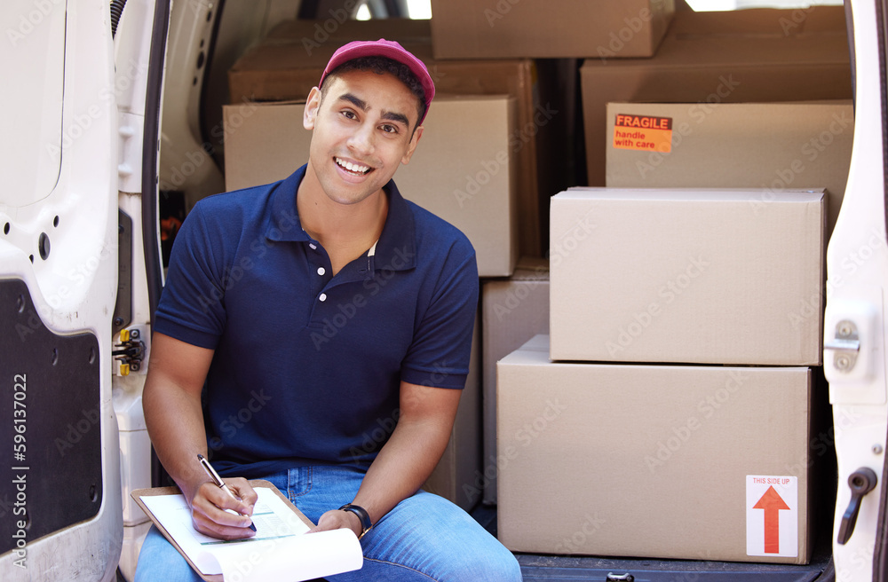 Poster Making double sure about all his deliveries. Portrait of a young delivery man writing on a clipboard while loading boxes from a van.