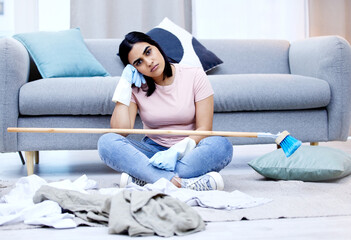 So many chores, so little time. a young woman taking a break from chores at home.