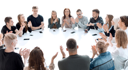 group of young people applauding, sitting at a round table