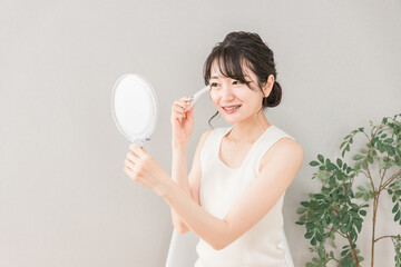 目元のシワ・たるみを美容グッズでケアするアジア人女性
