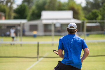 Amateur playing tennis at a tournament and match on grass in Europe 