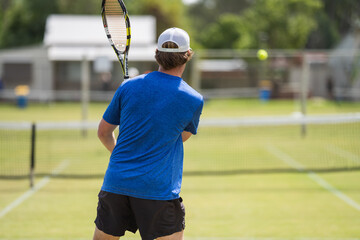 Amateur Tennis player, playing tennis at a tournament and match on grass in Europe