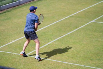 Amateur playing tennis at a tournament and match on grass in Europe 