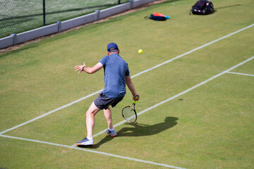 Amateur playing tennis at a tournament and match on grass in Europe 