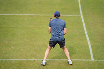 Amateur playing tennis at a tournament and match on grass in Europe 