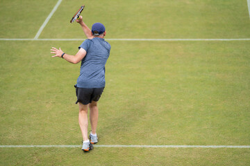 Amateur playing tennis at a tournament and match on grass in Europe 