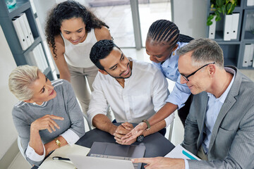 Going above and beyond to make their plans work. a group of businesspeople using a laptop together in an office.