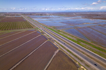 Aerial view of a field with a road. farmland on California. rice plantation 