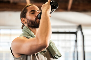 Stop to break, not to quit. a sporty young man drinking water while exercising in a gym.