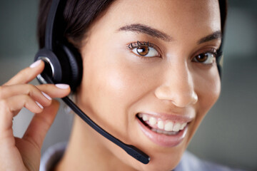 Im always ready to help. an attractive young call centre agent wearing a headset in the office during the day.