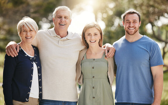 Portrait Of A Loving Caucasian Family With Adult Children Standing Together In Nature On A Sunny Day. Happy Senior Couple Posing Outdoors With Their Daughter And Son In Law