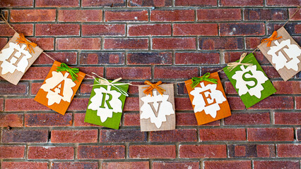 Fall Harvest sign hanging on brick wall